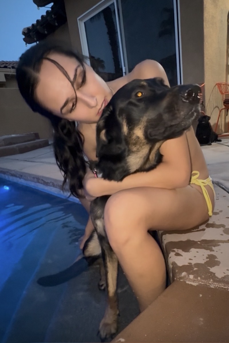 Angel hugging a rescued dog by the pool
